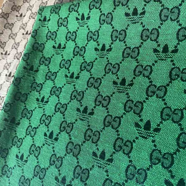 green jacquard fabric which has an adidas and gucci pattern combination.