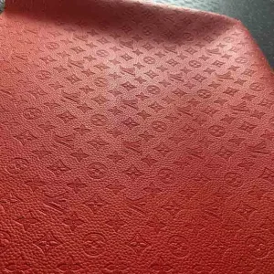 lv red empreinte bag fabric which has hot press patterns.