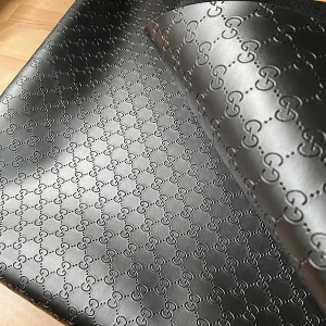 that black gucci vinyl fabric has hot press gg patterns on it. item is totally black without dye